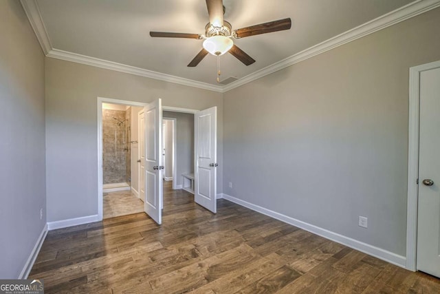 unfurnished bedroom with dark wood-style floors, ornamental molding, and baseboards