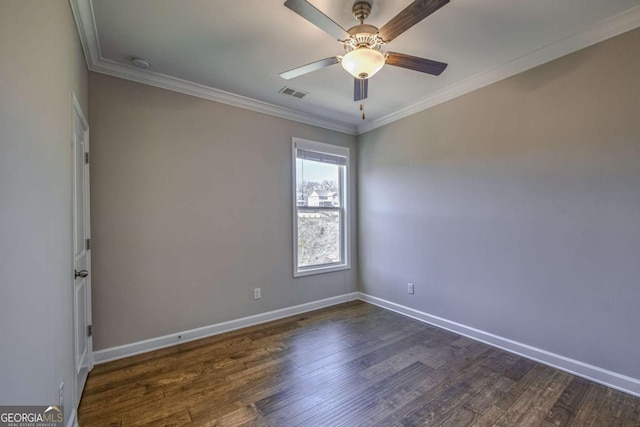 empty room featuring dark wood-style flooring, visible vents, and crown molding