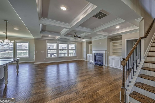 unfurnished living room with a healthy amount of sunlight, a fireplace with flush hearth, stairs, and visible vents