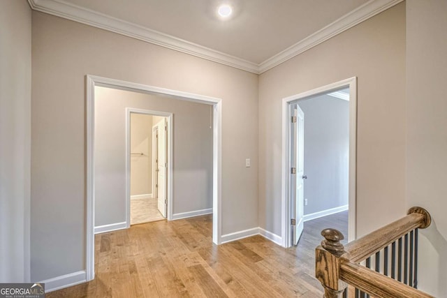 corridor featuring ornamental molding, light wood-style flooring, and baseboards