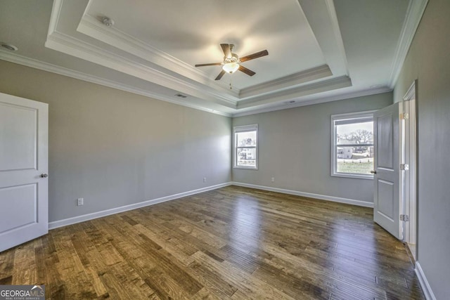 unfurnished bedroom featuring baseboards, a tray ceiling, and dark wood-type flooring