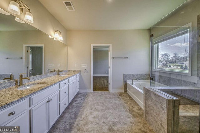 full bathroom featuring double vanity, visible vents, a sink, and a bath