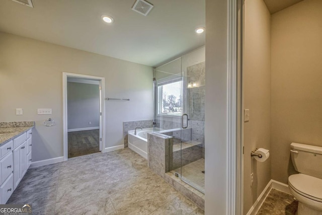 bathroom featuring toilet, vanity, visible vents, a bath, and a stall shower