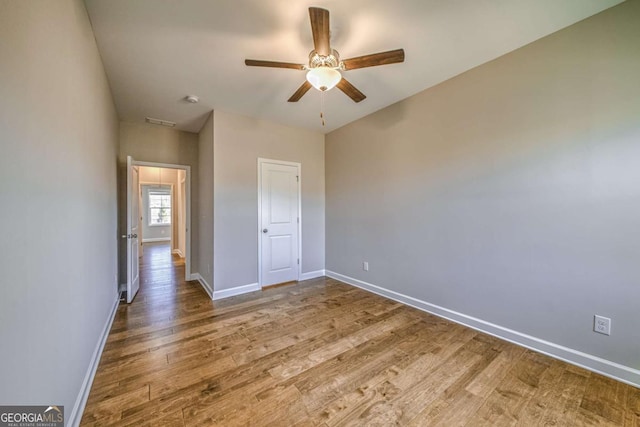 unfurnished bedroom with wood finished floors, a ceiling fan, and baseboards