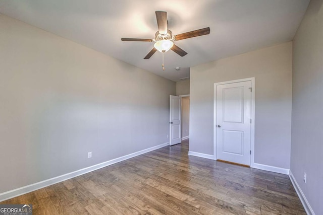 unfurnished bedroom featuring ceiling fan, dark wood finished floors, and baseboards