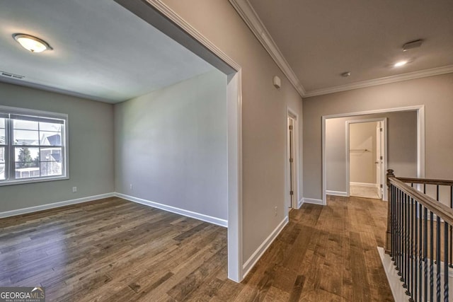 corridor with baseboards, visible vents, dark wood finished floors, and ornamental molding