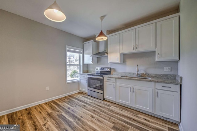 kitchen with electric range, a sink, white cabinets, wall chimney exhaust hood, and pendant lighting