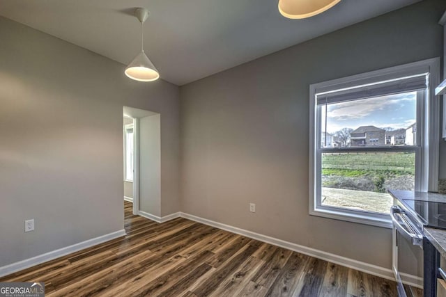 spare room featuring dark wood-style flooring and baseboards