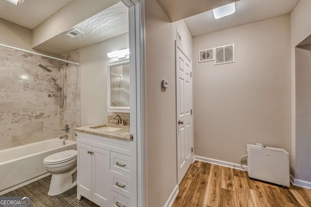 full bath featuring toilet, wood finished floors, visible vents, vanity, and  shower combination