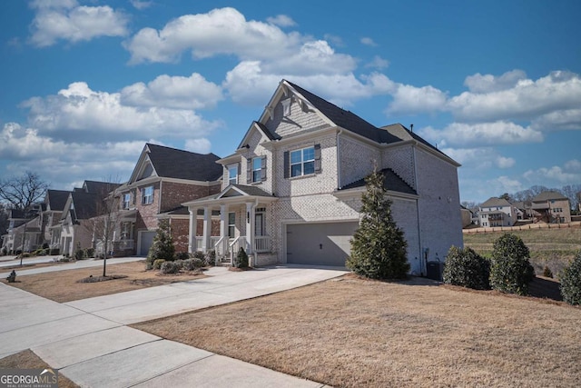 view of front of property featuring brick siding, concrete driveway, a residential view, an attached garage, and a front yard