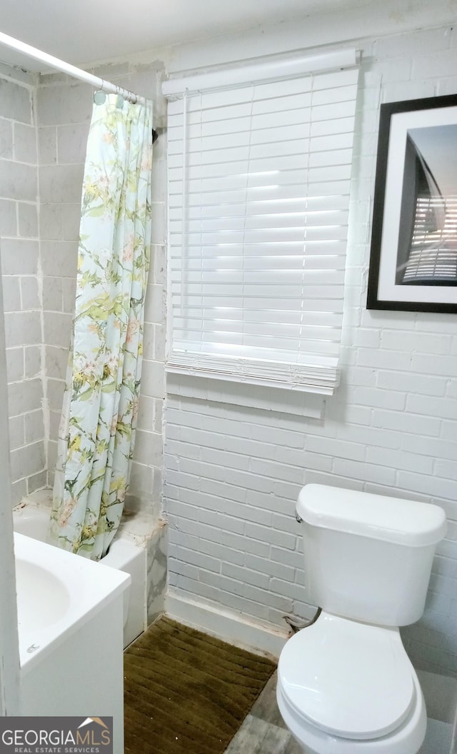 bathroom featuring toilet and shower / bath combination with curtain