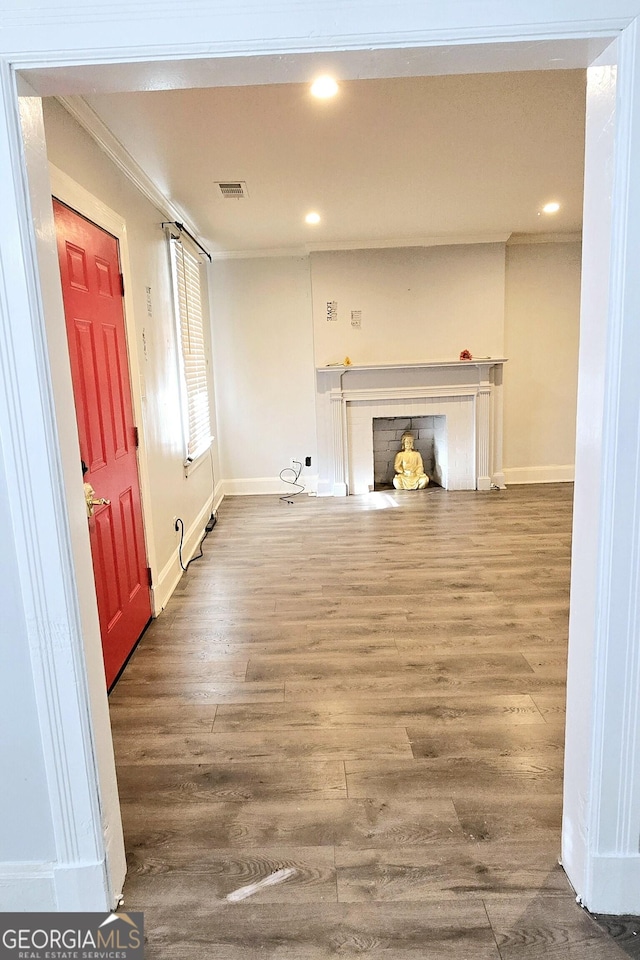 unfurnished living room featuring recessed lighting, wood finished floors, visible vents, baseboards, and ornamental molding