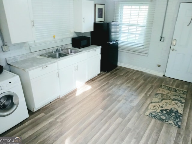 kitchen with washer / dryer, white cabinets, light countertops, and black appliances