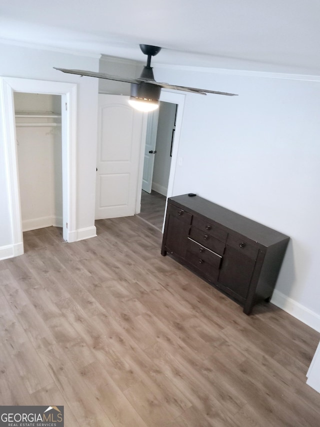 unfurnished bedroom featuring light wood-style floors, baseboards, and a closet