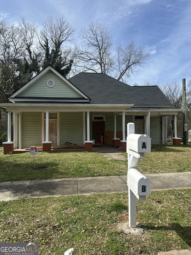 view of front of home with roof with shingles, a porch, and a front lawn