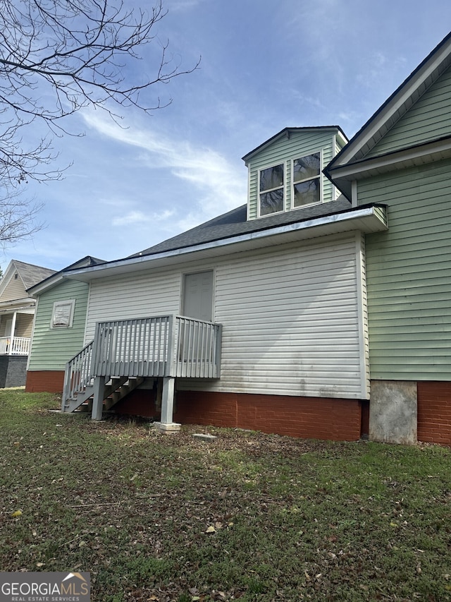 view of home's exterior featuring a deck and a lawn