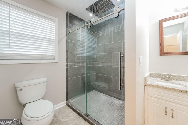 full bath featuring toilet, vanity, baseboards, tile patterned floors, and a stall shower