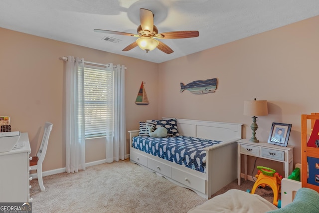 bedroom with light carpet, ceiling fan, visible vents, and baseboards