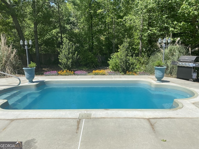 view of pool with grilling area, fence, and a fenced in pool