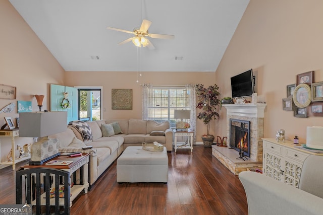 living room with a healthy amount of sunlight, a fireplace, high vaulted ceiling, and dark wood finished floors