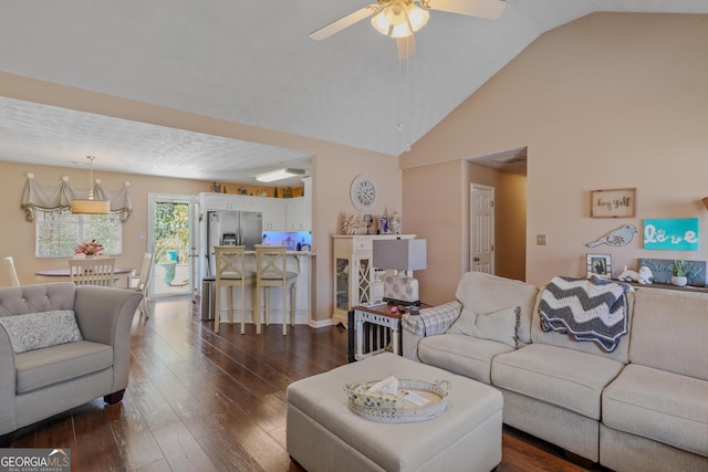 living area featuring high vaulted ceiling, dark wood finished floors, and a ceiling fan