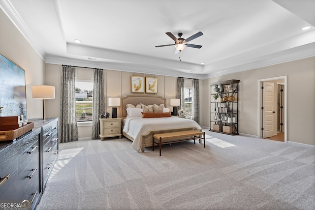 bedroom featuring light carpet, a tray ceiling, multiple windows, and recessed lighting