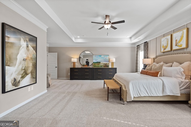 carpeted bedroom with ceiling fan, recessed lighting, baseboards, ornamental molding, and a tray ceiling