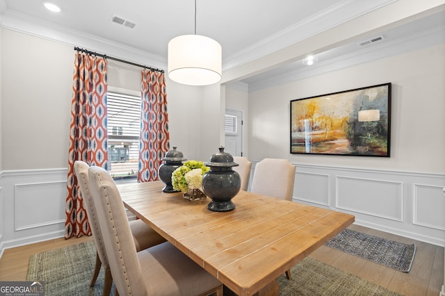 dining room featuring crown molding, visible vents, and wood finished floors