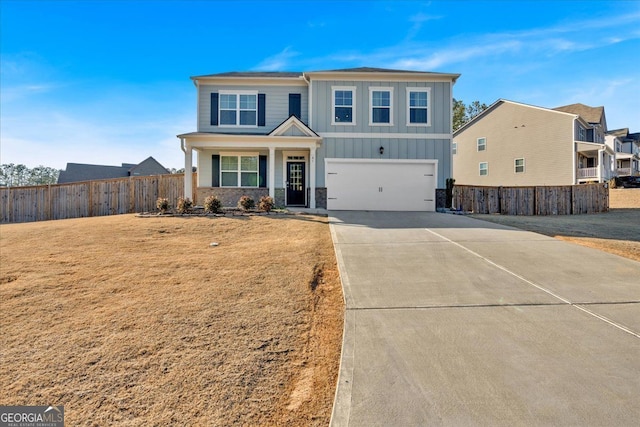 view of front of house with driveway, a garage, fence, a front lawn, and board and batten siding