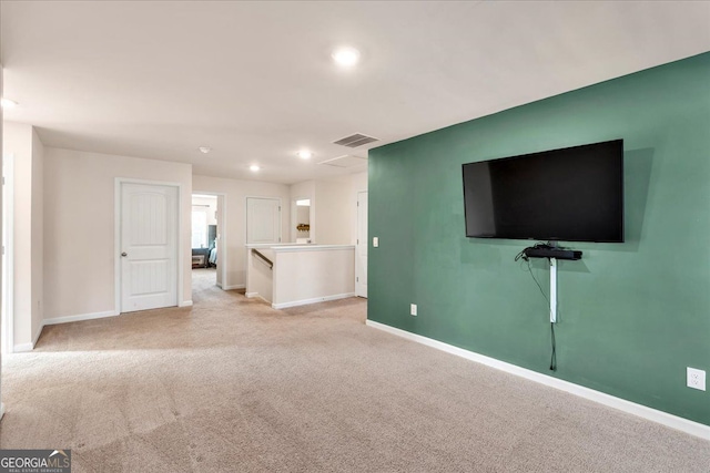 unfurnished living room with visible vents, baseboards, and light colored carpet