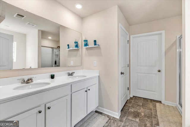 bathroom with a shower stall, visible vents, and a sink