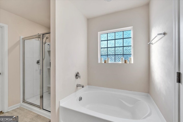 bathroom featuring a stall shower and a garden tub