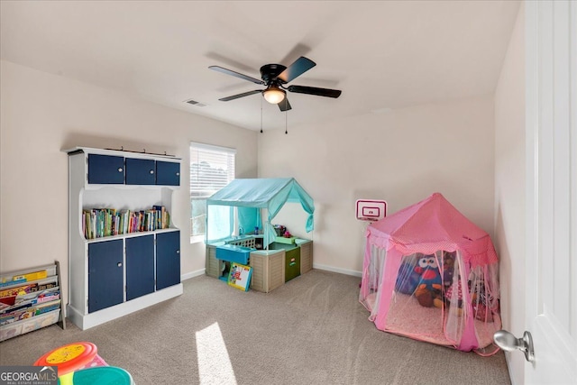 recreation room featuring a ceiling fan, carpet, visible vents, and baseboards