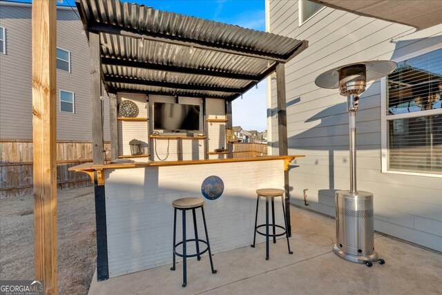 view of patio featuring fence and outdoor dry bar