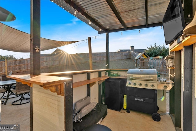 view of patio / terrace with outdoor dry bar, a fenced backyard, and a grill