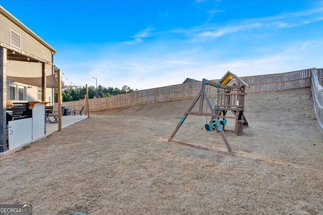 view of yard featuring a patio area, a playground, and a fenced backyard