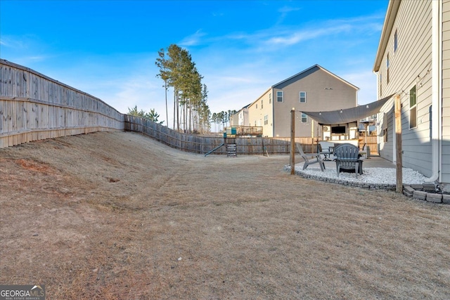 view of yard with a patio area, a fenced backyard, and a playground