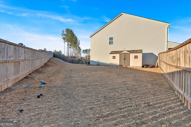 back of property featuring an outbuilding, a fenced backyard, and a storage unit