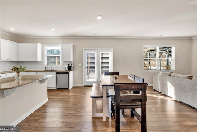 dining space featuring ornamental molding, recessed lighting, dark wood finished floors, and baseboards