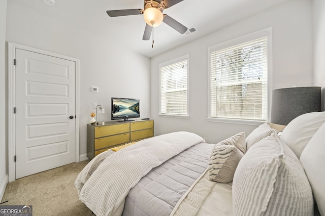 bedroom featuring light carpet, visible vents, and a ceiling fan