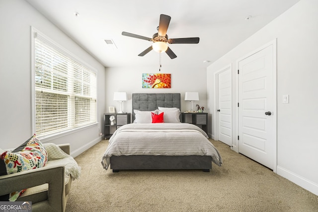 bedroom with baseboards, visible vents, and light colored carpet