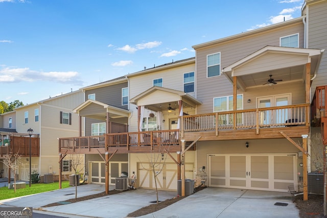 back of property with a garage, ceiling fan, central AC unit, and concrete driveway