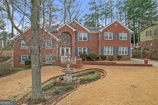 view of front of home featuring fence and brick siding