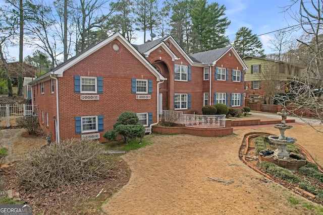 rear view of property featuring fence, a patio, and brick siding