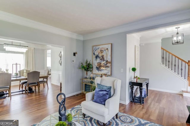 interior space with stairs, crown molding, wood finished floors, and a notable chandelier