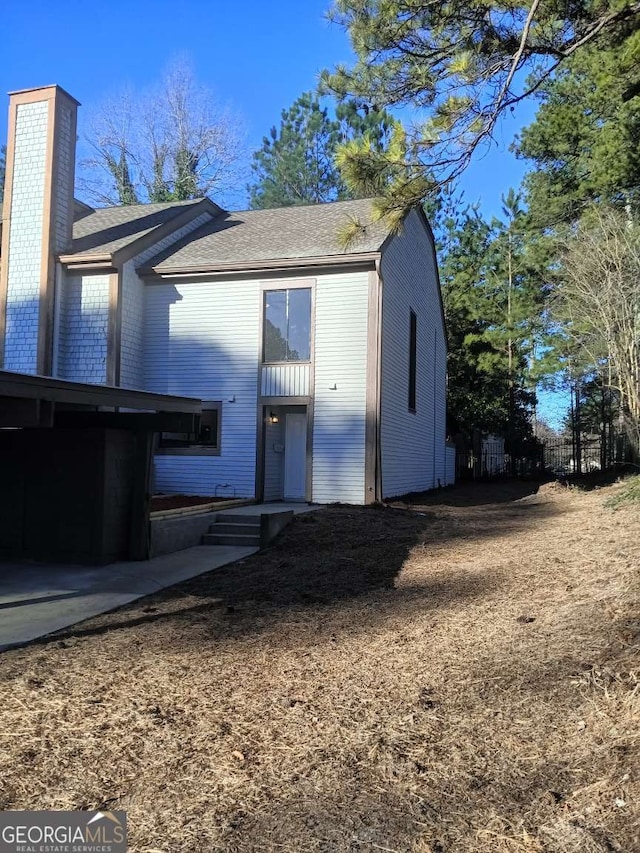 view of front of property featuring a chimney and fence