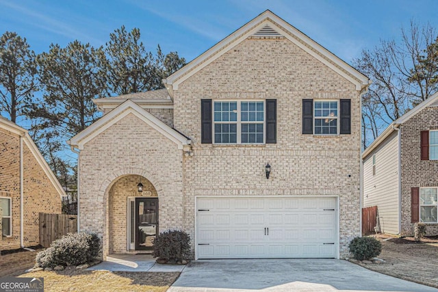 traditional-style house featuring an attached garage, fence, concrete driveway, and brick siding