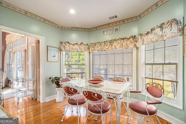 dining area with visible vents, baseboards, and wood finished floors