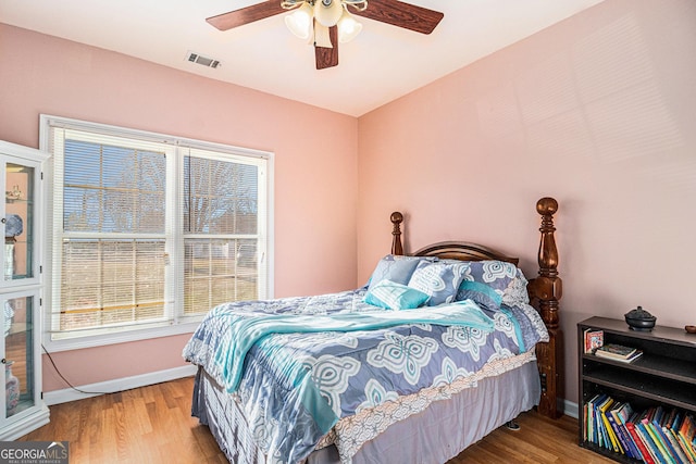 bedroom featuring baseboards, visible vents, and wood finished floors