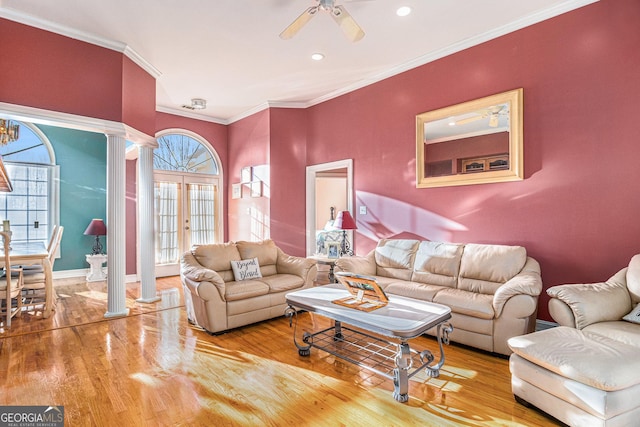 living area with a wealth of natural light, wood finished floors, and decorative columns